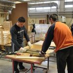 Team working on wooden pieces for construction site