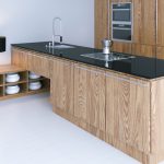 Kitchen island with wooden cabinets and black worktop