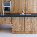 Modern kitchen with wooden cabinets and black quartz worktop