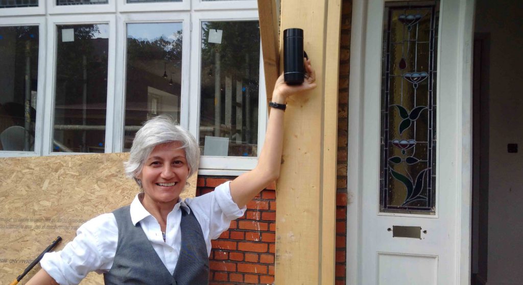 Annabella Nassetti posing next to a house renovation project