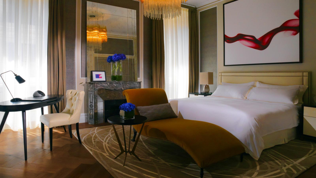 Modern hotel room featuring chaise longue and desk