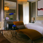 Modern hotel room featuring chaise longue and desk