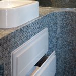 Storage solution in blue mosaic bathroom